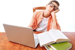 勉強の途中で寝る男性